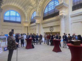 Guests gathered among project displays in a large hall.